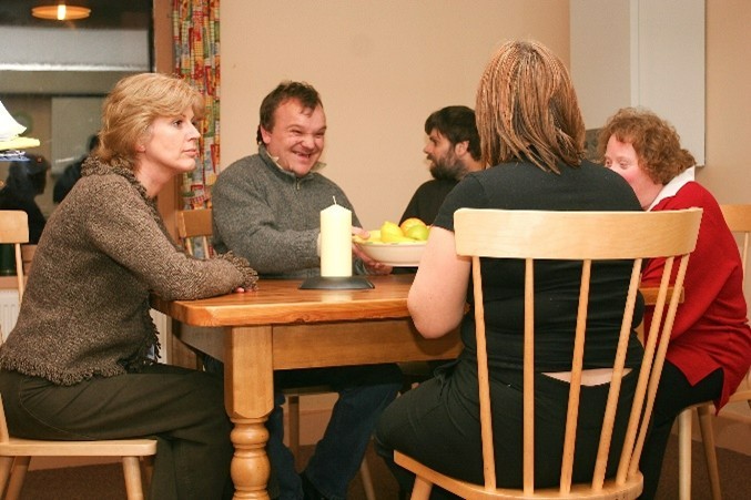 A group of people talking around a table