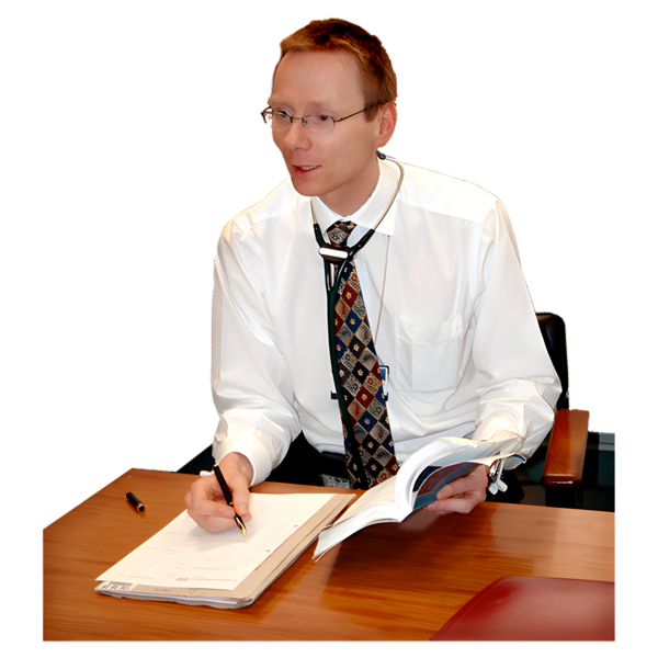 Doctor sitting at a desk with a pen and book in his hand