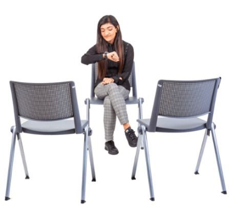 A woman sitting in a waiting room looking at her watch
