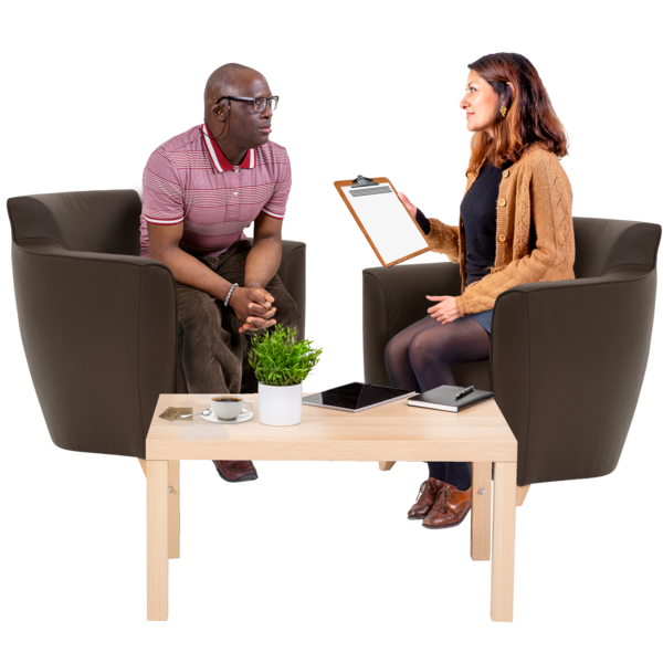 Two people sitting opposite each other talking. One of them is writing into a notepad.