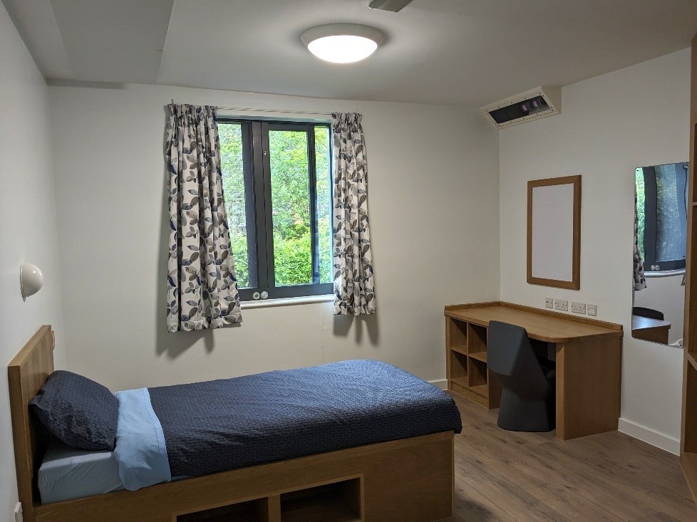 A bedroom in edenwood with a single bed and a dressing table and chair
