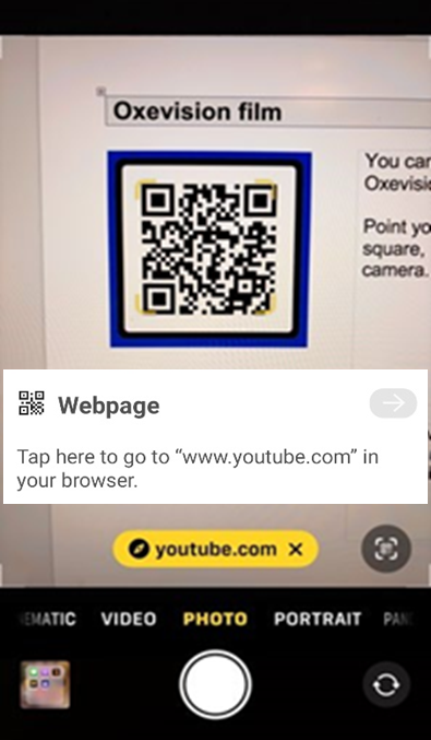 A Mobile phone with a QR code and YouTube link on the screen
