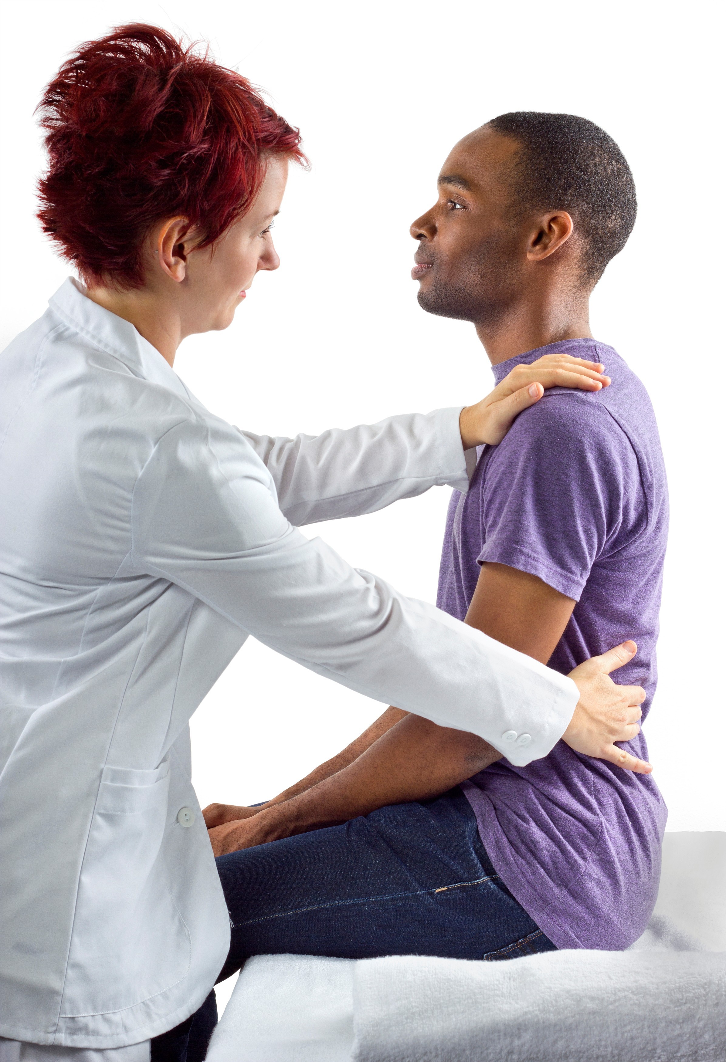 A therapist assisting a patient with a back exercise on a therapy table.