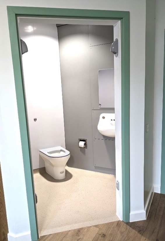 A view through the bathroom door in Edenwood ward. You can see a toilet and sink with a toilet and sink 