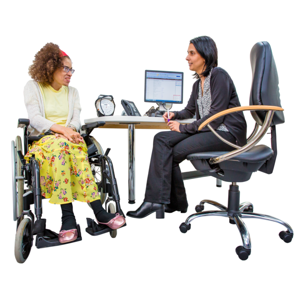 A woman in a wheelchair is sitting next to a health worker at her office desk