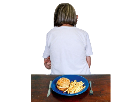 A plate of food is on a table. A person is sitting with their back to the food and table.