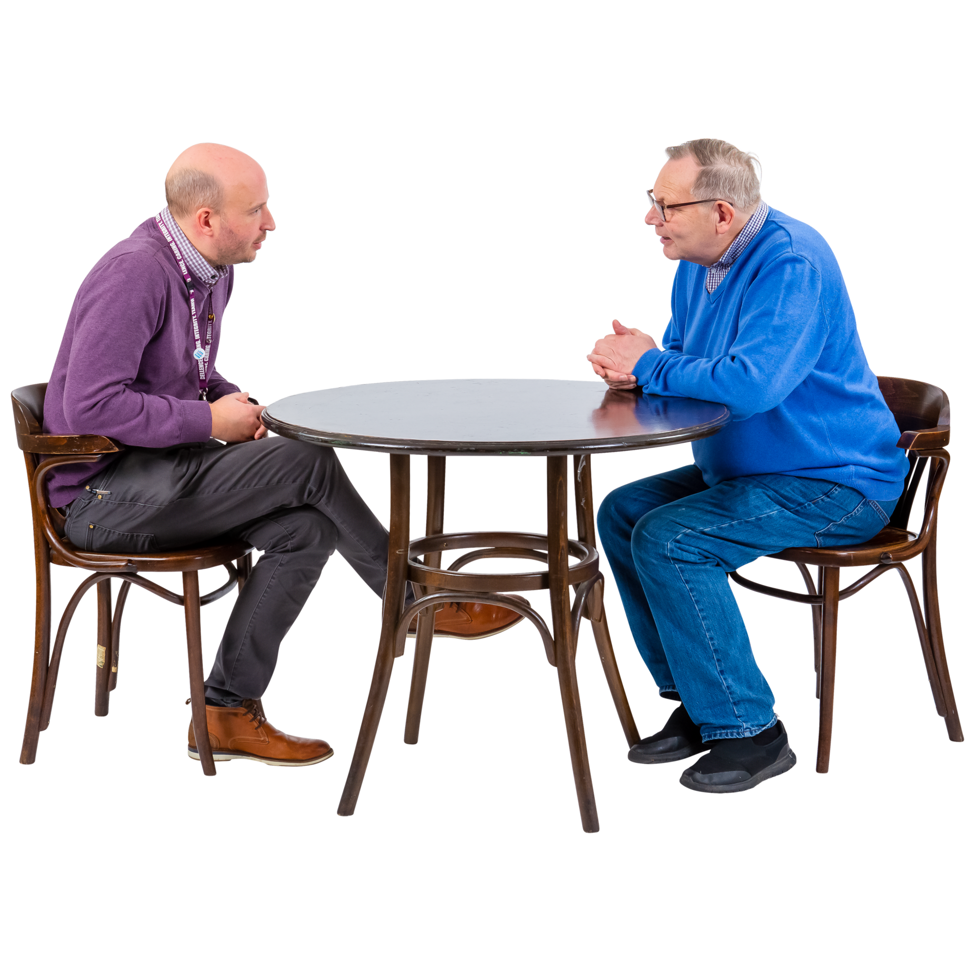 Two men having a conversation while seated at a round table.