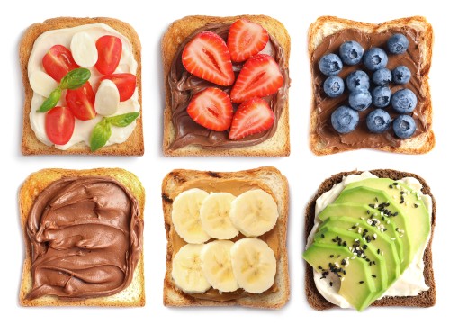 A selection of different toppings on toast such as fruit and chocolate spread