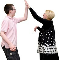 A boy and a woman making a 'high five' with their hands in the air