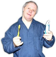 A man holding up a toothbrush in one hand and a tube of toothpaste in the other hand