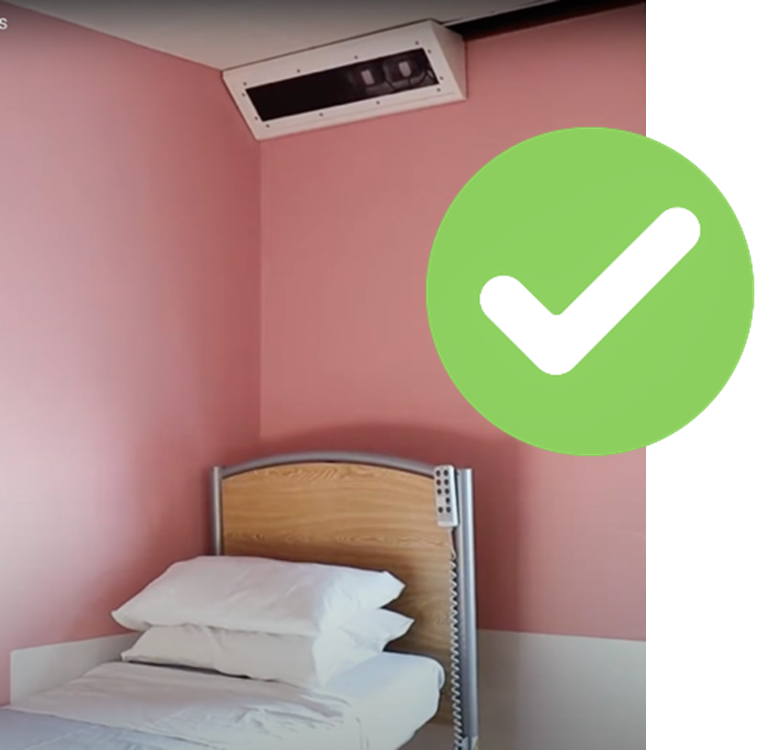 The Oxevision camera on the ceiling above a bed, with a green tick