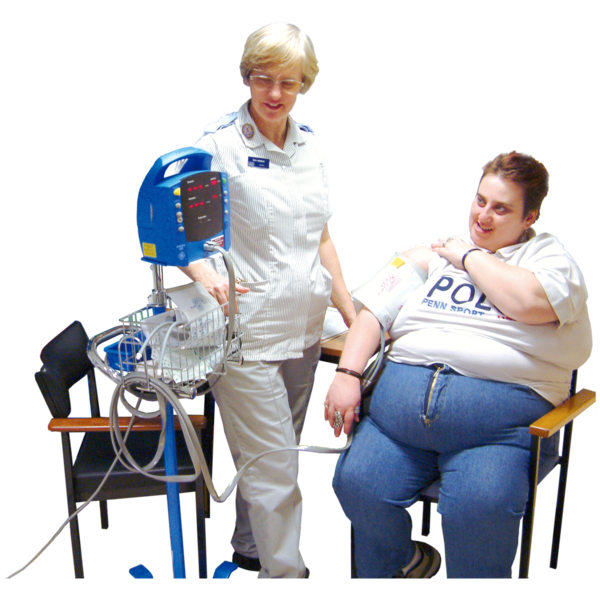 A person sitting on a chair having their blood pressure taken by a nurse