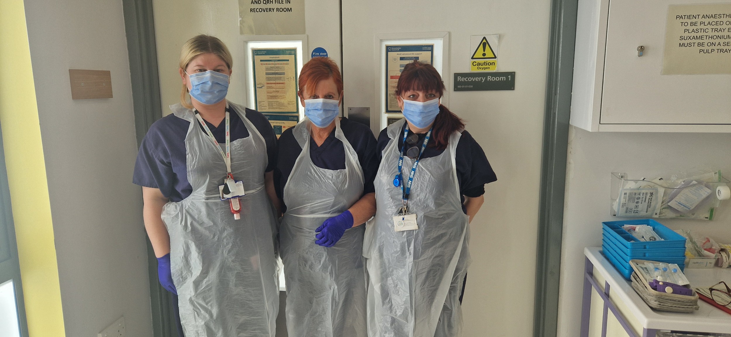 3 members of ECT Staff wearing masks, gloves and plastic aprons