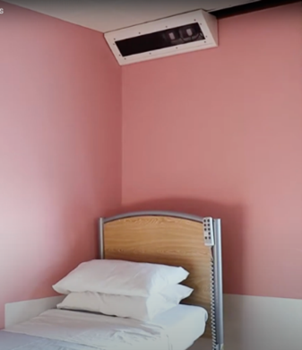 The Oxevision camera on the ceiling above a bed