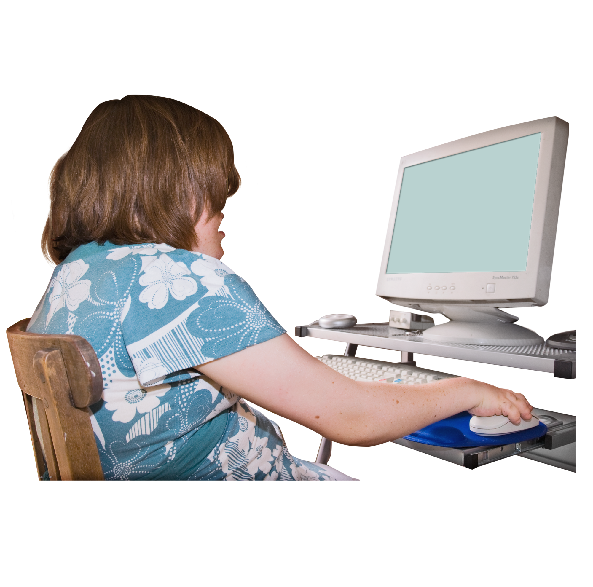 A person in a floral shirt using a desktop computer with an adaptive keyboard.