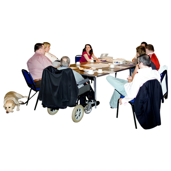 A diverse group of people in a meeting, with some in wheelchairs and a guide dog present.