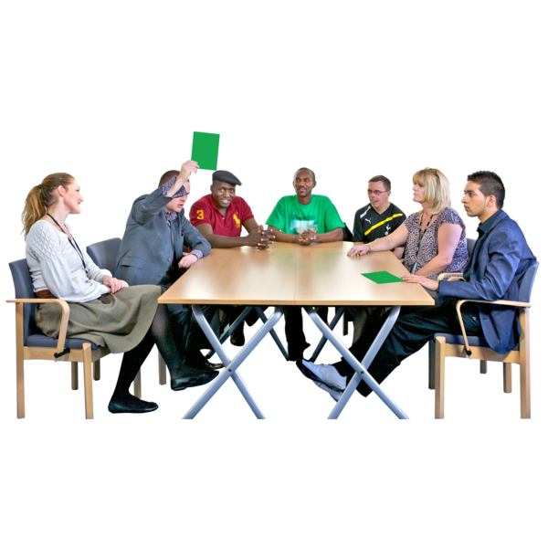 Group of people around a table voting with green cards