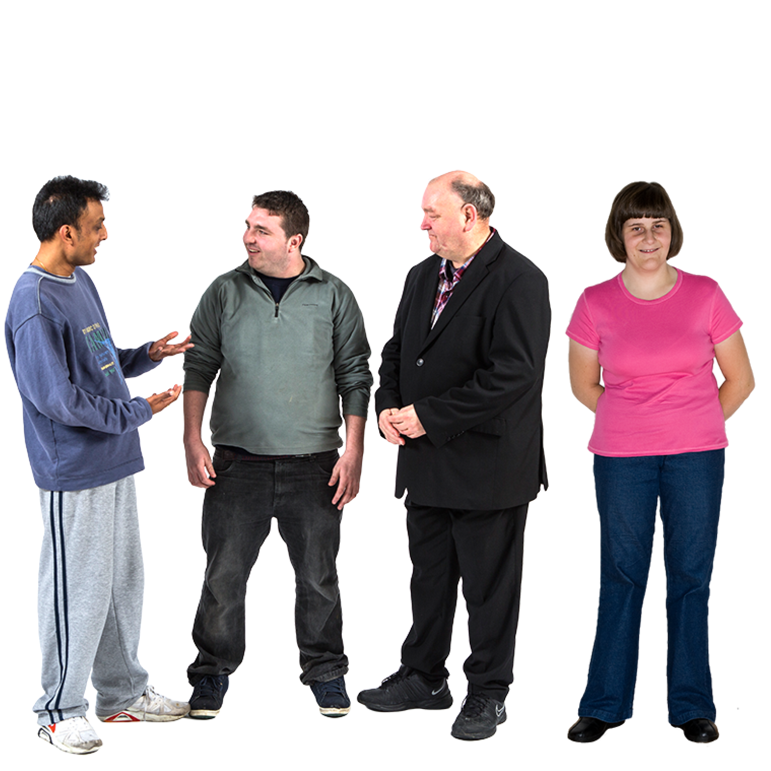 Three men standing together, one in casual clothes, another in a green pullover, and a third in a black suit, engaged in conversation. A woman standing  next to them in a pink shirt and blue jeans with her hands behind her back.