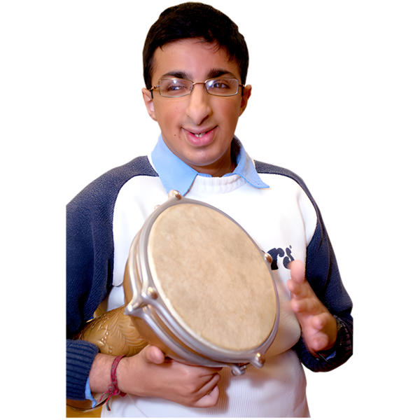 A young person with glasses holding a small drum and smiling.