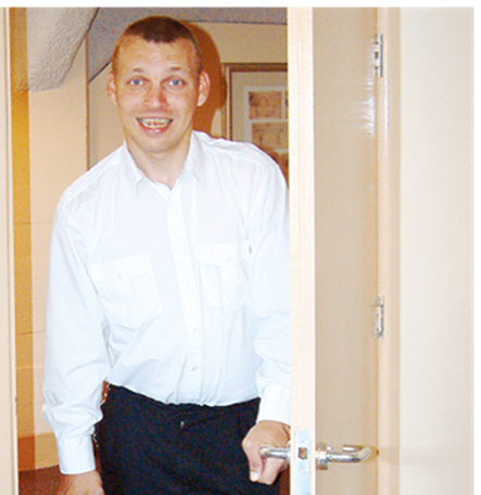 A person opening a door and walking in to a room