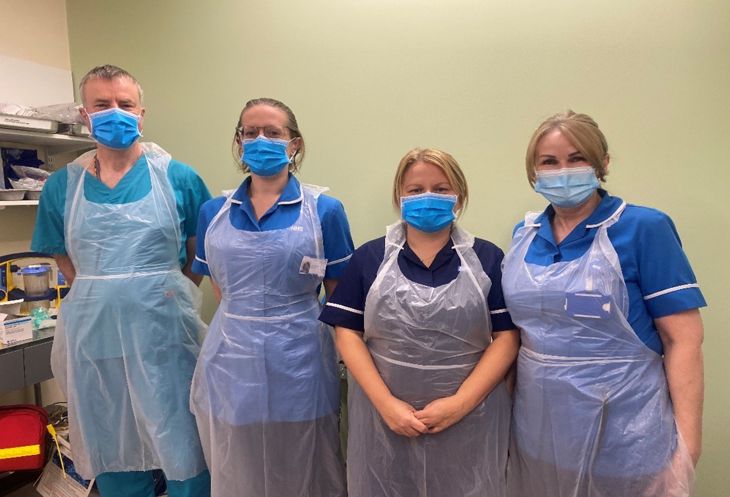 4 members of ECT staff wearing masks and plastic aprons