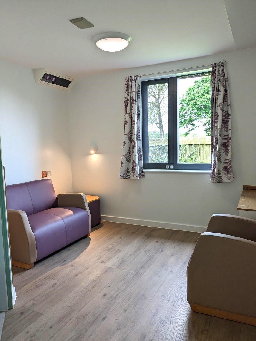 A lounge room with a sofa, chair and side table