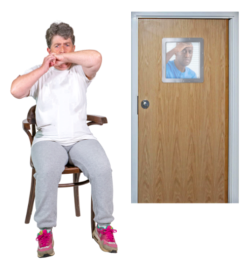 A person in a locked room sitting on a chair. A nurse is looking into the room through a window.