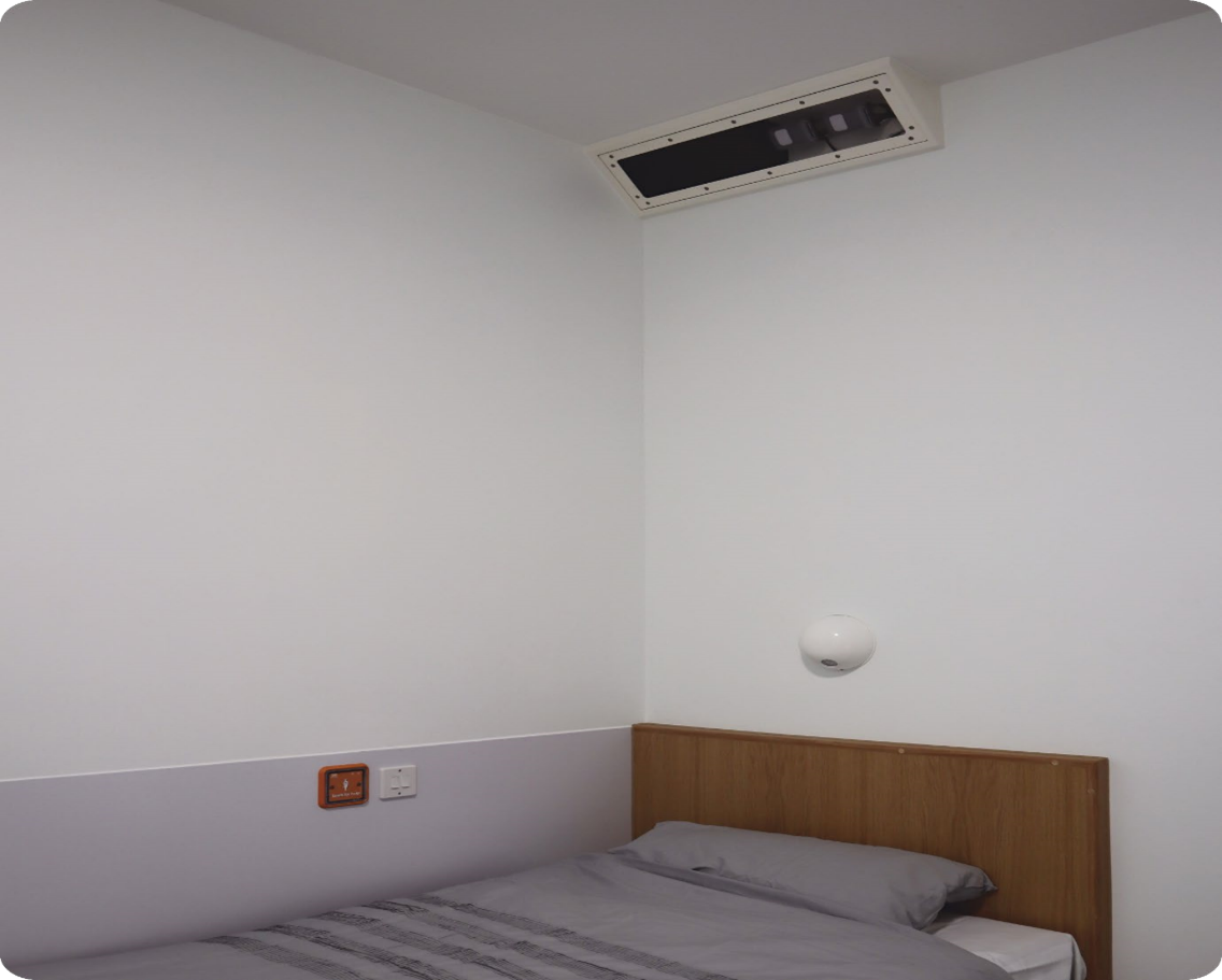 The Oxevision box on the ceiling above a bed