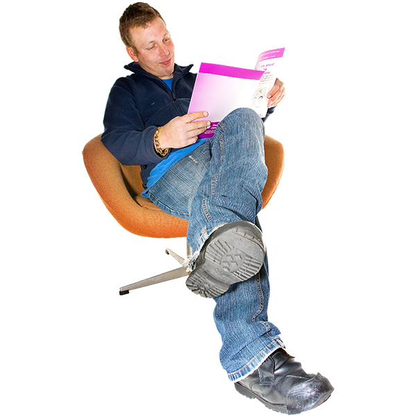 Man sitting on an orange chair reading a magazine