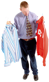 A man holding a shirt and tracksuit top