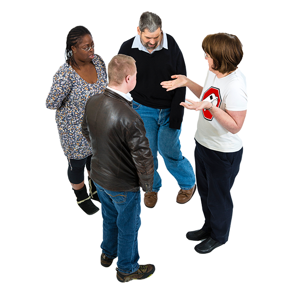 Four adults standing in a circle having a discussion.