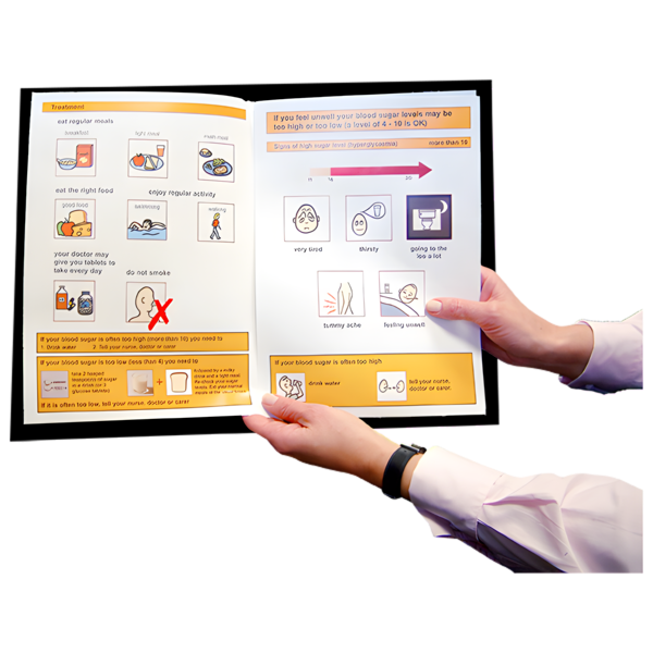 A person holding an open booklet with diabetes management information